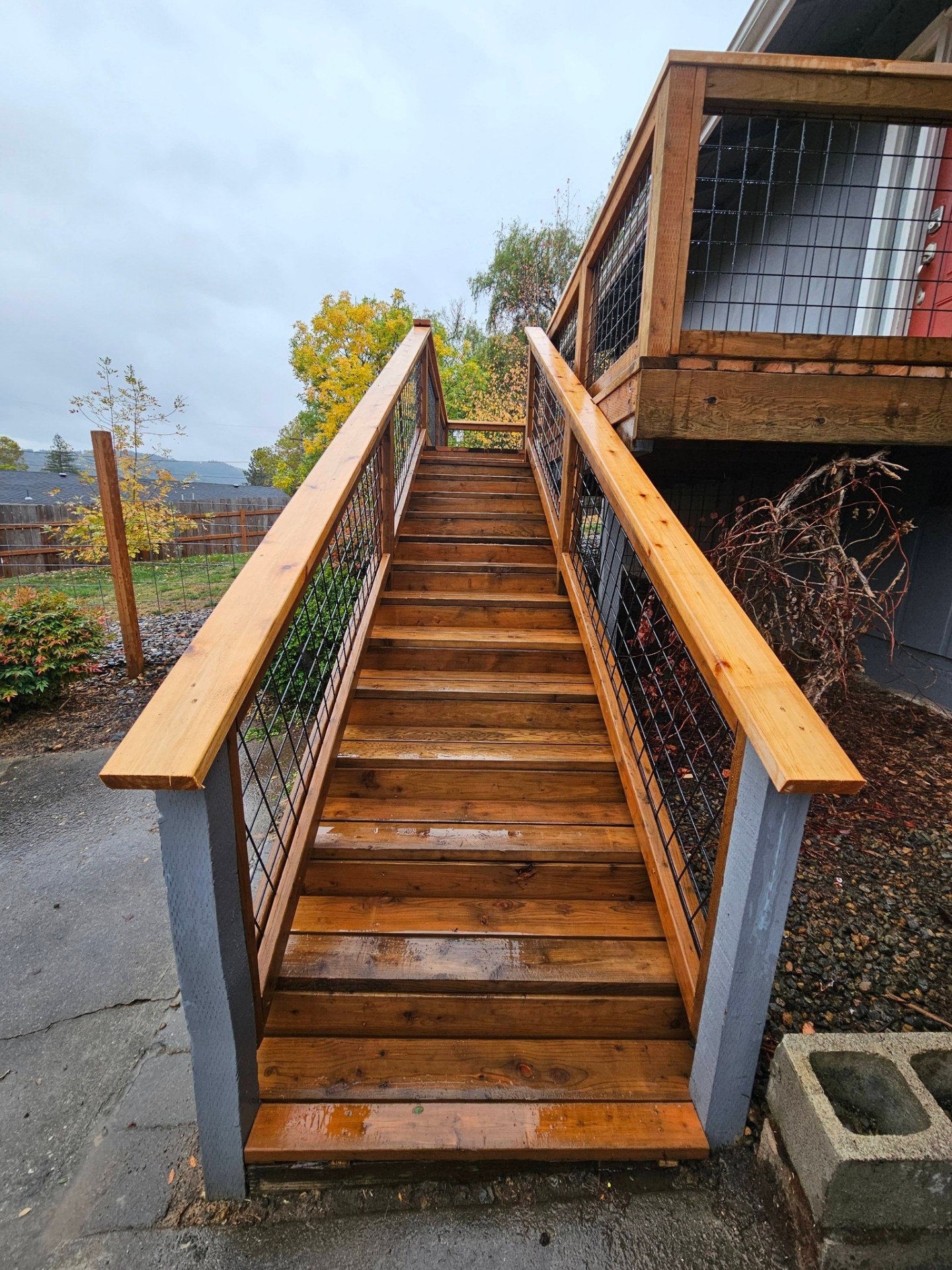 Wide cedar staircase with hog-wire railings viewed from below