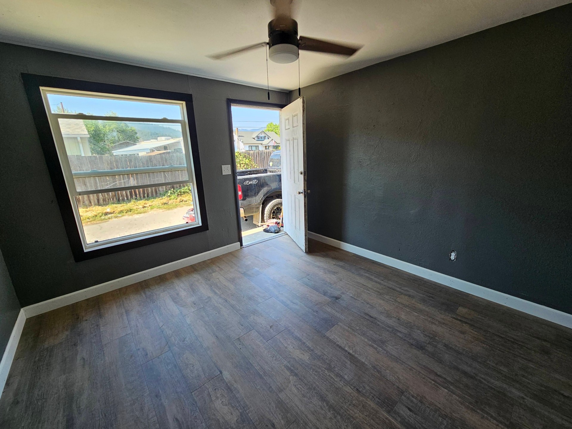 Bedroom with bold charcoal accent walls and new vinyl plank floors