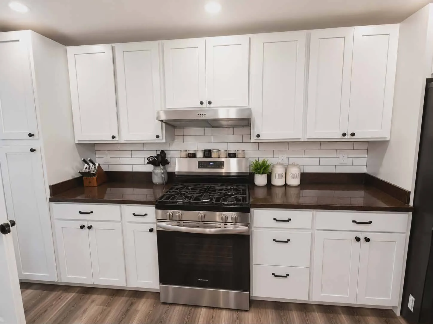 White shaker kitchen with subway tile backsplash and dark quartz counters