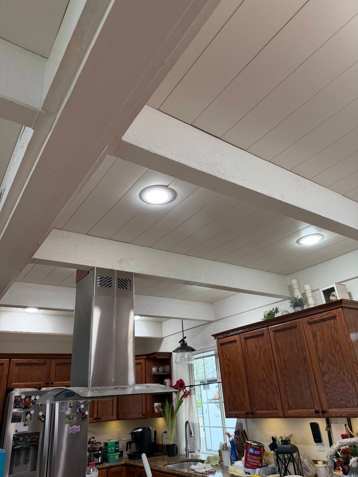 Kitchen ceiling with worn painted beams before refinishing