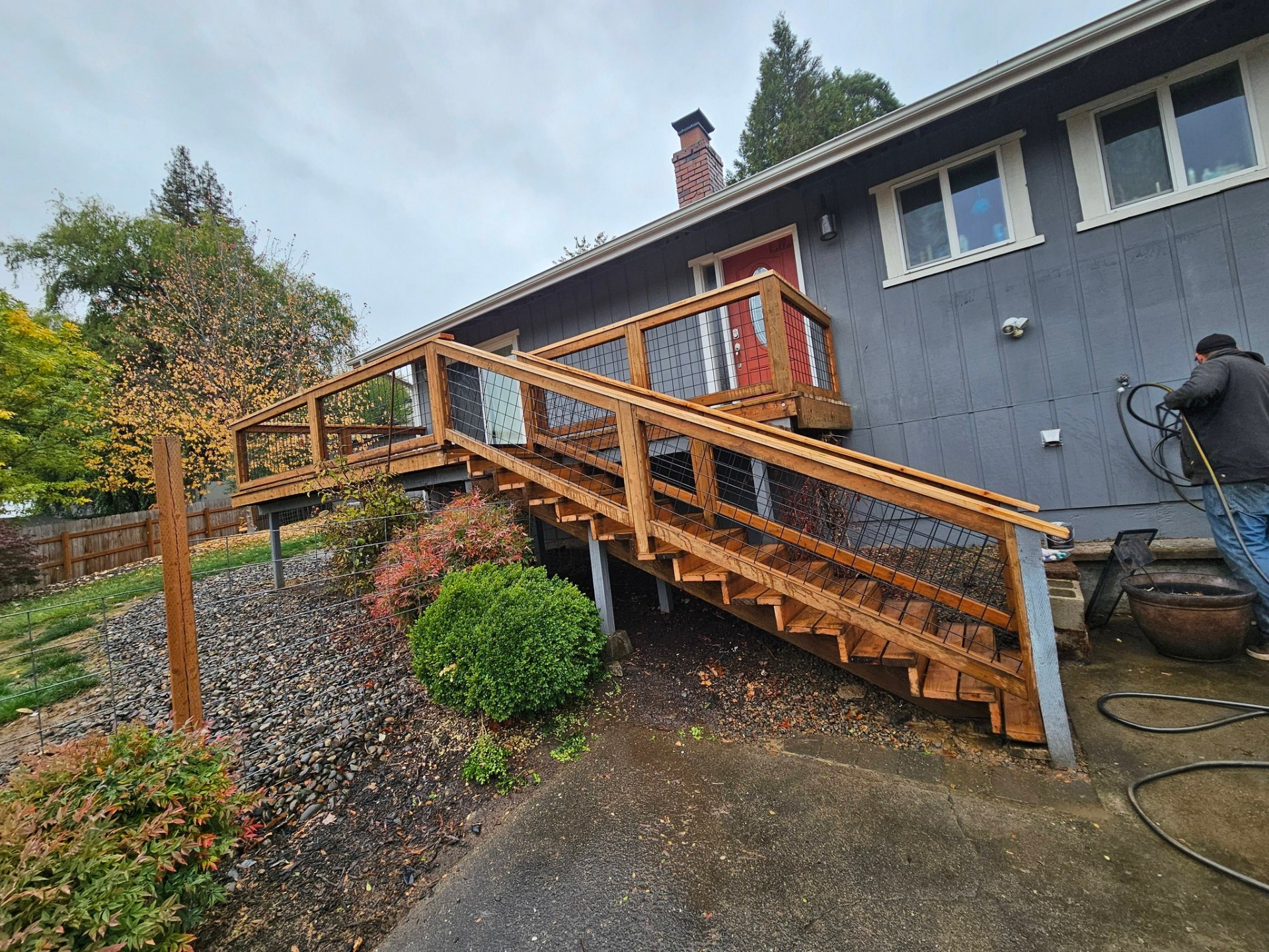 Long cedar staircase and landing leading to a hillside home's entry