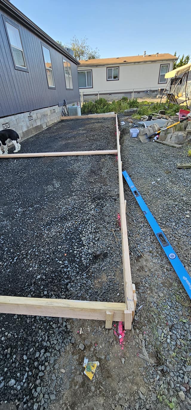 Leveled gravel pad with pressure-treated framing staged for a new build