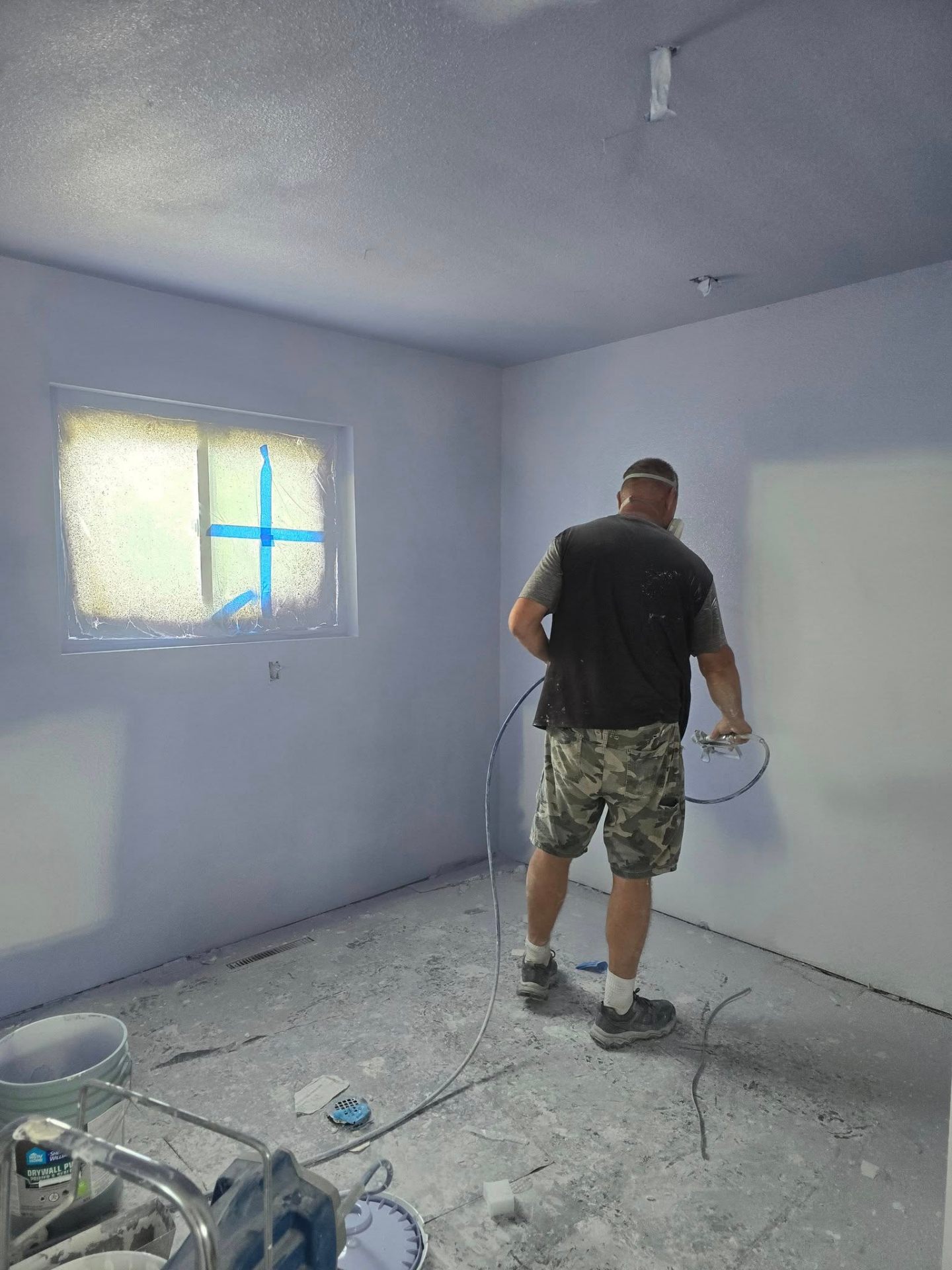 Crew member spraying interior walls during a full repaint