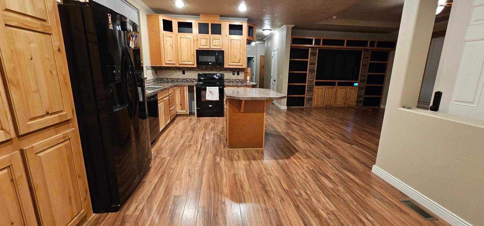 Open concept kitchen with knotty alder cabinets and new vinyl plank flooring